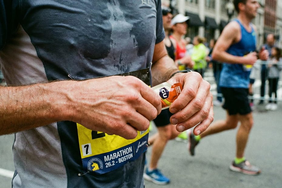 Runner utilizza gel energetico durante una maratona.